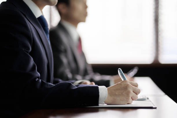 At the hands of an Asian businessman listening to a presentation at a meeting